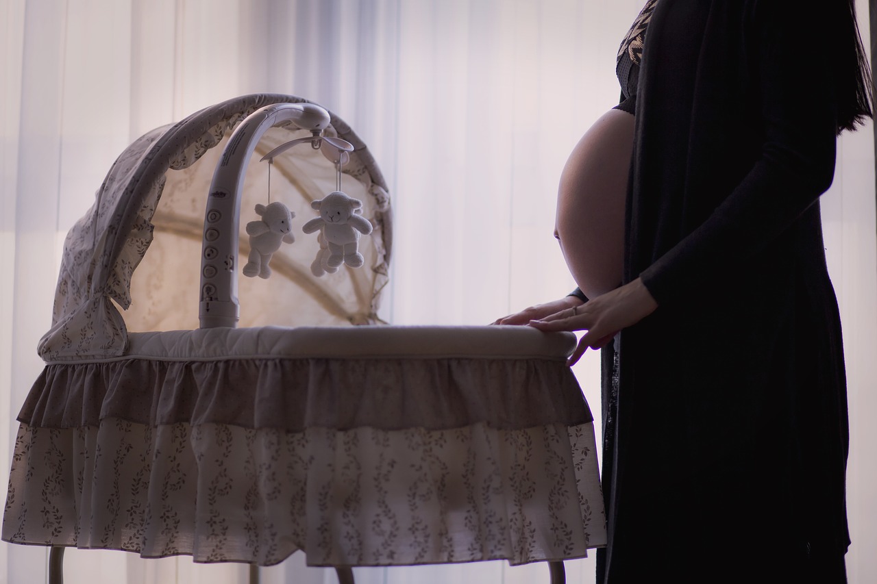 Berceau en bois clair avec linge de lit doux dans une chambre d'enfant
